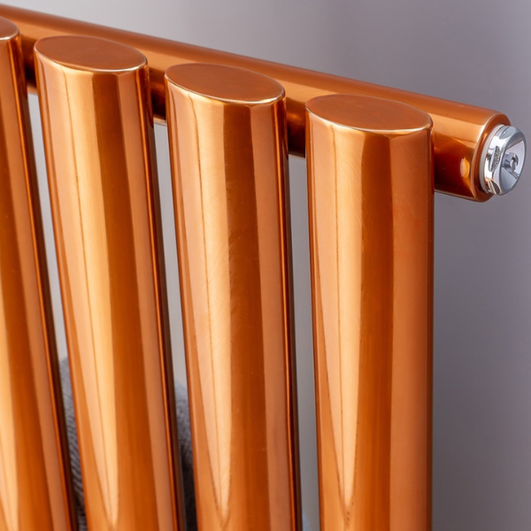 A close up shot of teh corner of a copper column radiator. You can see four of its columns coated in a vibrant and shiny copper lacquer.